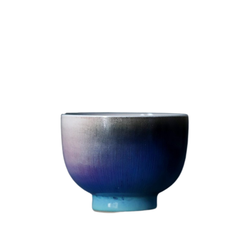 A ceramic tea cup with a gradient of blue to purple color.