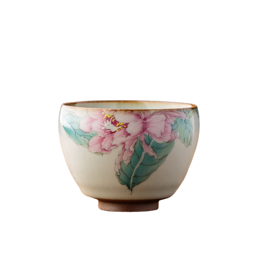A painted ceramic tea cup with a floral design, predominantly pink and green, on a white background.