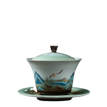 A ceramic tea cup with a deer symbol and a floral pattern on a green background, displayed on a matching green plate.