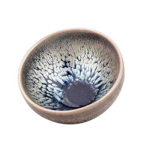A round art ceramic tea cup with a swirling blue and gray Tenmoku glaze and a copperfield symbol in the center.