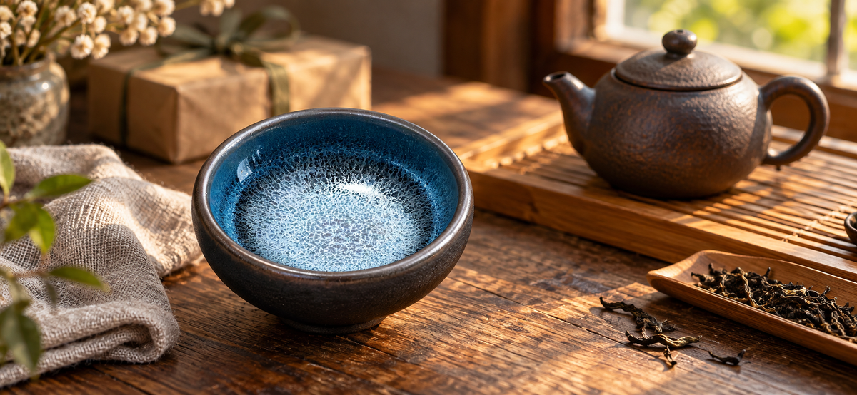 Blue Kirin Jianzhan teacup on a sunlit tea table with teapot and gift wrapping