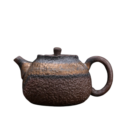 A vintage brown ceramic teapot with a rustic finish and a handle on the side.