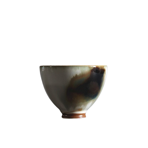 A ceramic art tea cup with a floral pattern and a brown base.