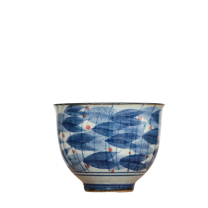 A ceramic tea cup with blue and white colors, featuring a geometric pattern.