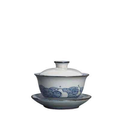 A white and blue ceramic Gai Wan with a floral pattern, featuring a lid and a handle.