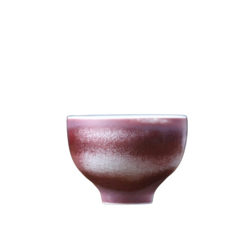 A purple and brown ceramic art tea cup with a textured surface.