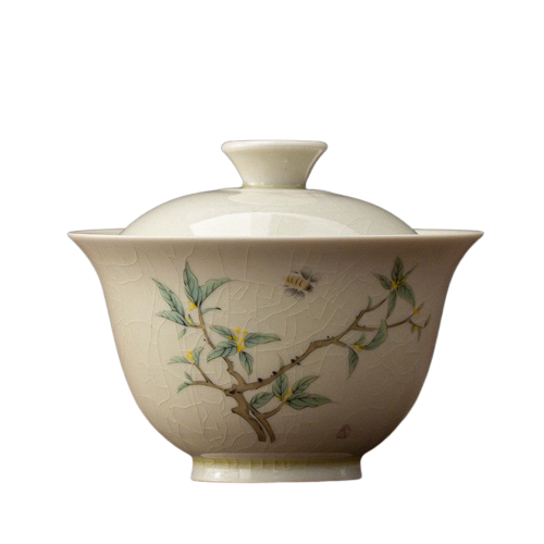 A beige ceramic tea cup with floral and insect patterns, including a prominent bee, indicative of the Osmanthus flower.