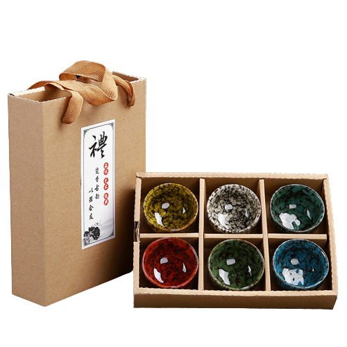 A set of six multicolored ceramic teacups in a gift box with a natural brown paper exterior and a decorative orange ribbon on top.