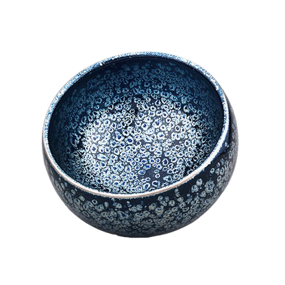 A round ceramic tea cup with a blue and gray speckled pattern.