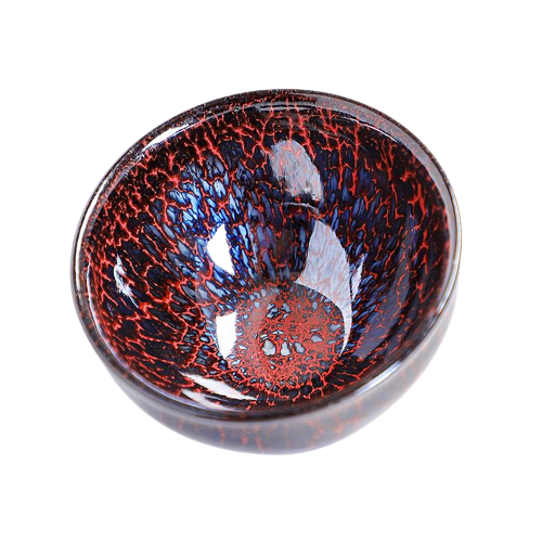 A round, high-temperature ceramic tea cup with a red and blue speckled pattern and a central dark red spot.