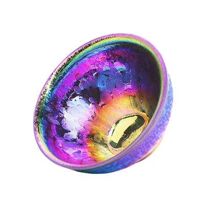 A multicolored, round ceramic teapot with a glossy finish and a central golden ring.