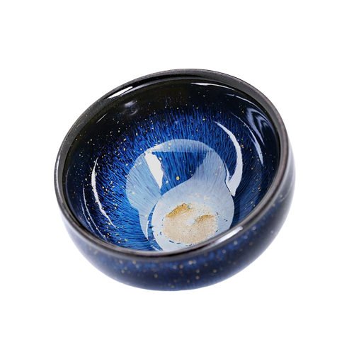 A blue and black ceramic tea cup with a floral pattern and a piece of tea leaf inside, showcasing the cup's color and design.