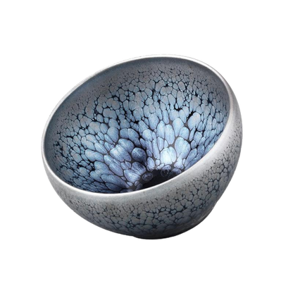 A round, blue and gray tenmoku tea cup with a textured surface.