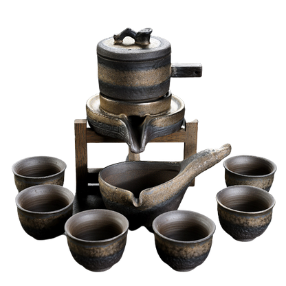 A set of brown ceramic tea set items, including a pot and several cups, with a textured artistic glaze.