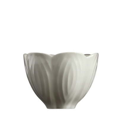 A white ceramic teacup with a floral pattern on a black background.