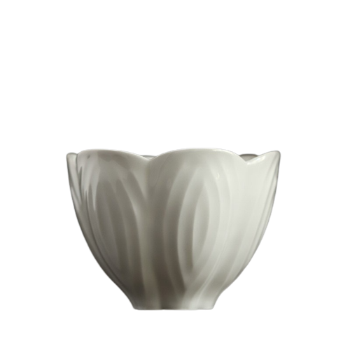 A white ceramic teacup with a floral pattern on a black background.