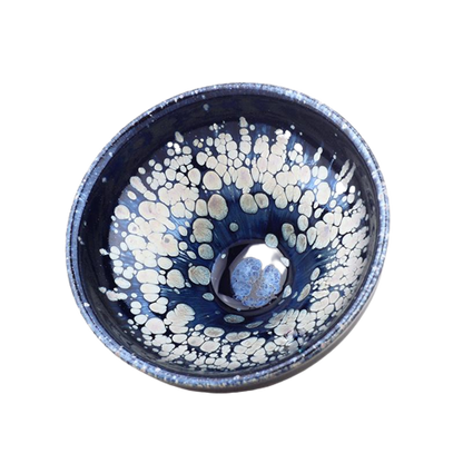 A blue and white tenmoku teapot with a snowflake pattern and a central handle.