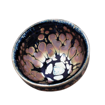 A ceramic tea cup with a sunset-like pattern in peach and moss green colors.